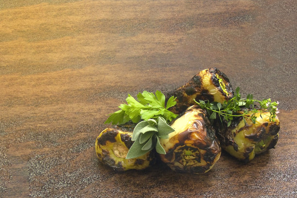 照片展示了烤甜椒和绿色蔬菜。烤椒摆放在深色木质背景上。图片下载