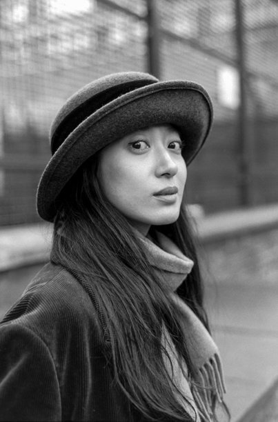 年轻的亚洲女性戴着帽子和围巾，在黑白胶卷照片中摆姿势图片下载