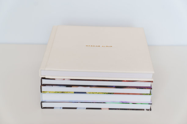 皮革封面的书上用金色字母写着“婚礼相册”，书本上还有照片封面。图片下载