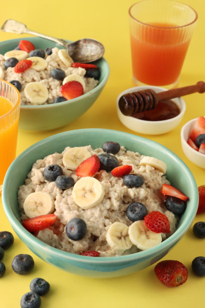 健康早餐的图片，燕麦粥、蓝莓、草莓、香蕉片、蜂蜜、橙汁、葡萄柚汁 / 营养丰富的早晨餐，搭配新鲜水果。图片下载