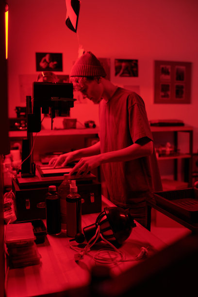 摄影师在暗房中使用放大机设备冲洗照片打印件图片下载