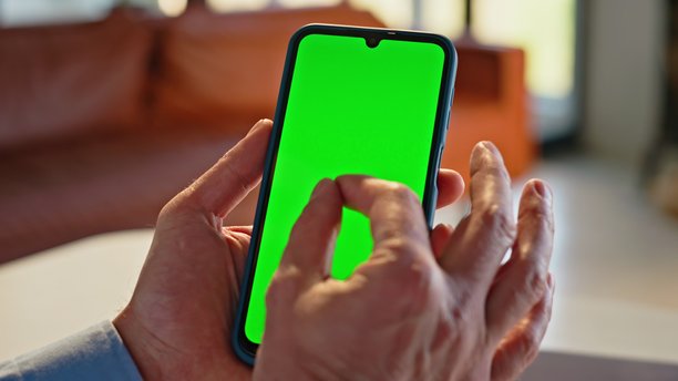 工人在工作场所近距离查看绿色背景的手机照片图片下载