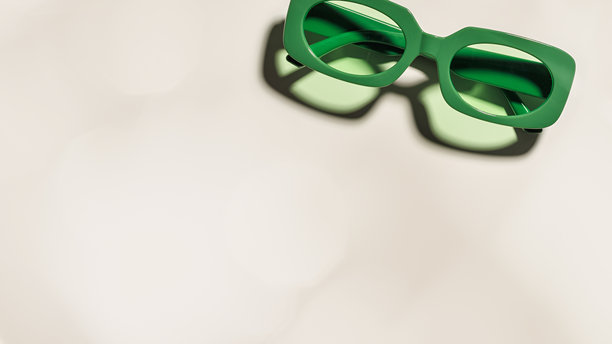 时尚的绿色太阳镜，透明绿色镜片，放置在米色横幅上，阳光投下的阴影，夏季时尚塑料框眼镜。美学俯视眼镜照片，时尚眼镜。图片下载