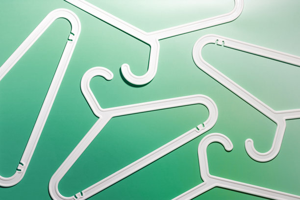 白色塑料衣架的顶部视图，带钩子，置于白绿色背景上。平铺的衣物架用于悬挂衣物。极简风格的照片，生活方式或室内设计概念。图片下载