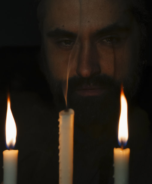 低光环境中燃烧蜡烛的强烈凝视。竖版照片图片下载