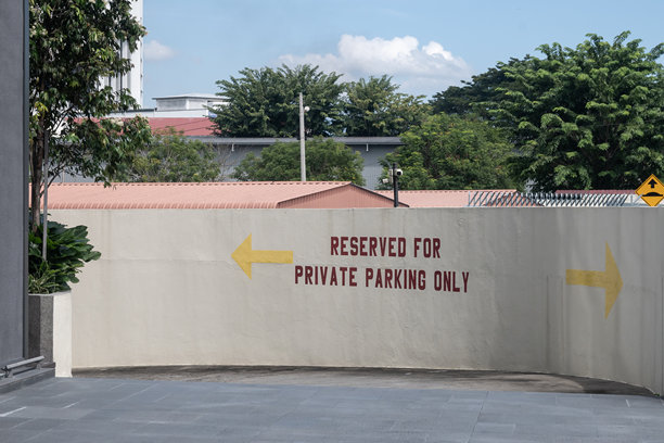 停车场入口的照片，上面写着“仅限私人停车”，两侧有指向左和右的箭头。图片下载
