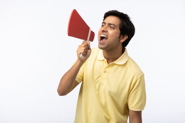 穿着黄色T恤的惊讶男士在空白背景下大声喊叫，手持扩音器的照片图片下载