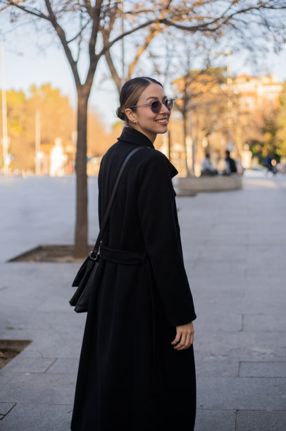 时尚年轻女性在晴朗的冬日里微笑着漫步于城市中 - 股票照片。图片下载