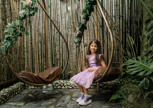 女孩坐在乡村秋千上，周围是竹子和热带自然风光 - 股票照片。图片下载