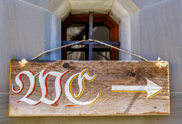 阳光明媚的日子里，历史建筑内窗边的指向箭头的乡村风格木牌图片下载