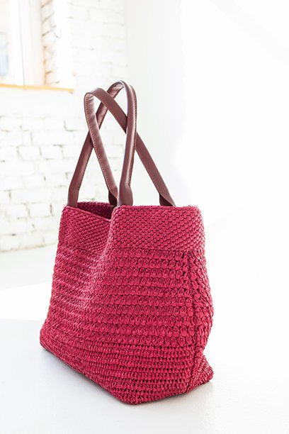 时尚的红色编织包在浅色背景上。时尚与奢华配饰。竖版照片。图片下载