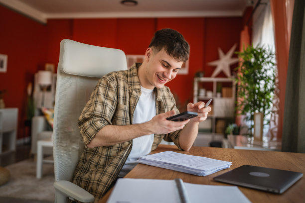 年轻男学生在家学习时拍摄笔记照片图片下载