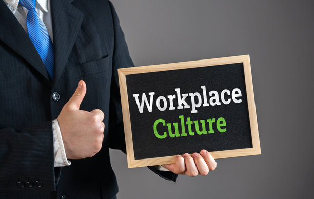 商人手持“职场文化”标志并竖起大拇指表示赞同。积极的公司环境、团队合作、企业价值观、员工参与。办公室士气。图片下载
