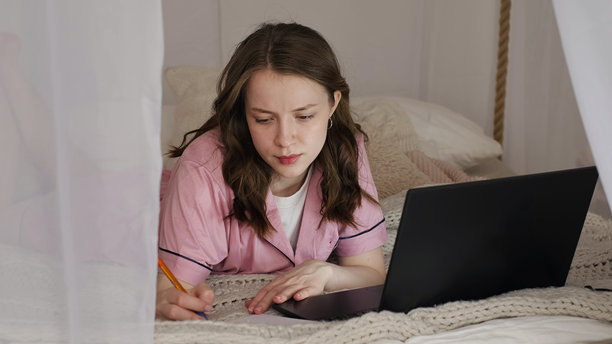 一位女性专注于她的任务，在宁静的极简环境中结合数字和手写工作。这张照片展示了传统与现代工作风格之间的平衡。图片下载