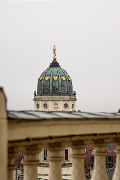 新德国大教堂圆顶特写。标志性的柏林地标，金色雕像细节，从法国教堂的屋顶露台俯瞰，背景是柔和的天际线。极简主义照片。留白空间。图片下载