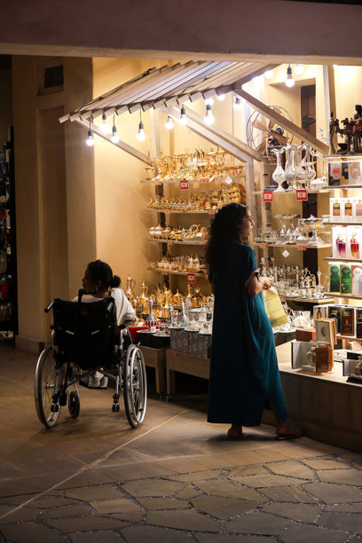 阿联酋迪拜 - 2024年9月29日 一位坐在轮椅上的残疾女性在商店橱窗附近。编辑类图片图片下载