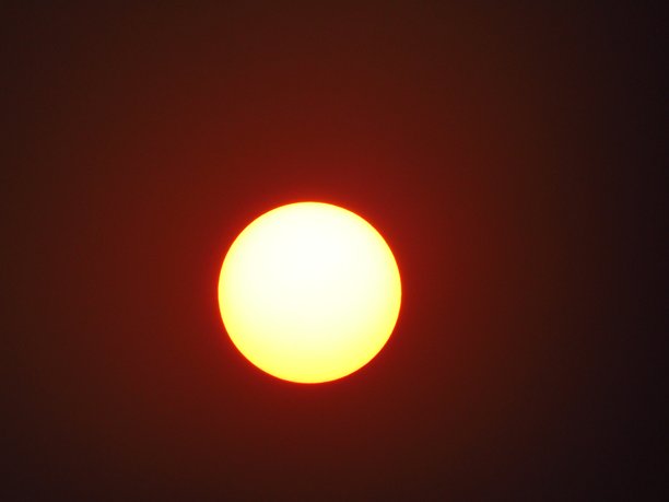 城市黄昏时分的大日落特写照片，夕阳景色。图片下载