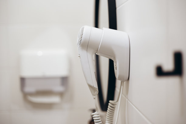 一台白色吹风机挂在浴室的墙上。室内照片。图片下载