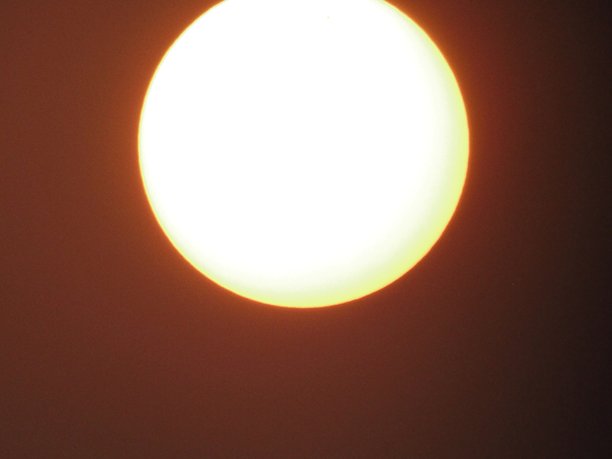 城市黄昏时分的大日落特写照片，夕阳景色。图片下载