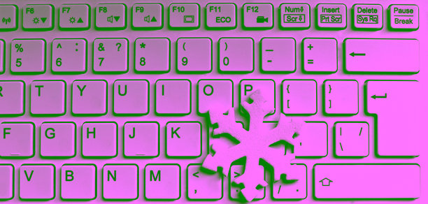 3D打印的雪花静静地躺在白色笔记本电脑键盘上。适合IT工作者的贺卡设计的库存照片。图片下载