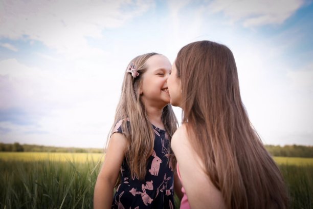 母女在美丽的田野中玩得开心。春夏摄影。快乐的童年，幸福与欢笑。母爱的关怀。照片的主题是母亲节和儿童节。图片下载