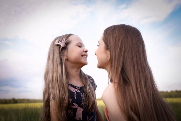 母女在美丽的田野中玩得开心。春夏摄影。快乐的童年，幸福与欢笑。母爱的关怀。照片的主题是母亲节和儿童节。图片下载