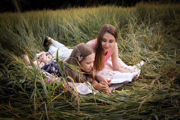 母女在美丽的田野中玩得开心。春夏摄影。快乐的童年，幸福与欢笑。母爱的关怀。照片的主题是母亲节和儿童节。图片下载