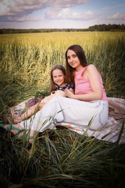 母女在美丽的田野中玩得开心。春夏摄影。快乐的童年，幸福与欢笑。母爱的关怀。照片的主题是母亲节和儿童节。图片下载