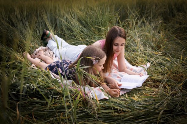 母女在美丽的田野中玩得开心。春夏摄影。快乐的童年，幸福与欢笑。母爱的关怀。照片的主题是母亲节和儿童节。图片下载