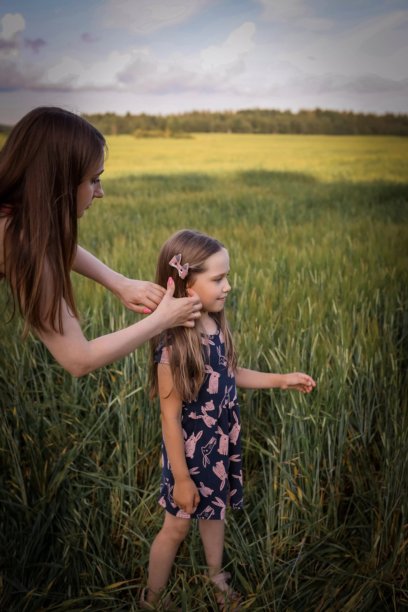 母女在美丽的田野中玩得开心。春夏摄影。快乐的童年，幸福与欢笑。母爱的关怀。照片的主题是母亲节和儿童节。图片下载