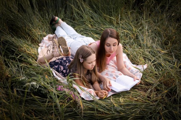 母女在美丽的田野中玩得开心。春夏摄影。快乐的童年，幸福与欢笑。母爱的关怀。照片的主题是母亲节和儿童节。图片下载