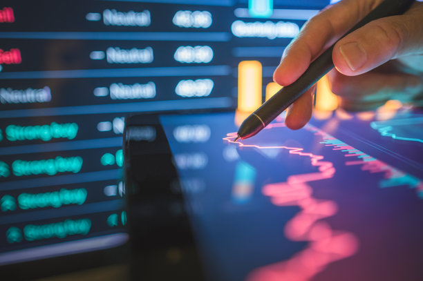 投资者在市场下跌期间使用手写笔在平板电脑上分析价格走势，研究数字屏幕上的蜡烛图模式和实时股票。图片下载