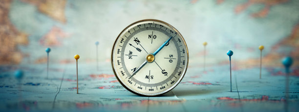 磁性指南针和世界地图上用图钉标记位置的路线。冒险、发现、导航、通信、物流、地理、交通和旅行主题概念背景。微距照片。非常浅的焦点。图片下载