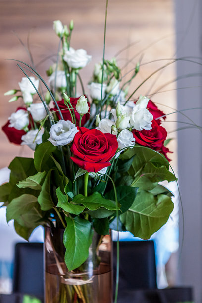 户外花瓶中的花。夏季照片，包含玫瑰和简单的白色花朵。图片下载
