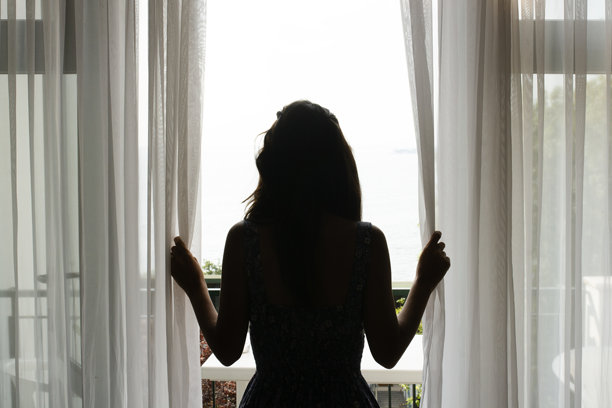 女人在窗边凝视的剪影。库存照片图片下载