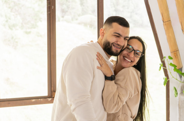 幸福的情侣在灯塔里拥抱微笑 - 股票照片图片下载