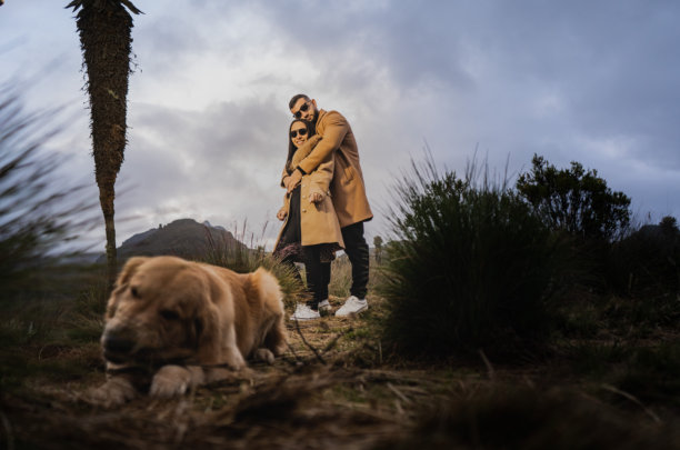 一对情侣在山中散步时与他们的狗一起依偎在大自然中 - 股票照片。图片下载