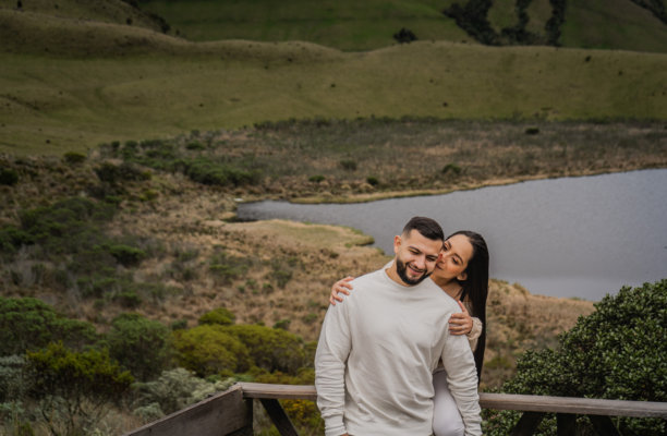 女人在湖泊和山脉的自然风景前温柔地拥抱和亲吻她的伴侣 - 股票照片图片下载