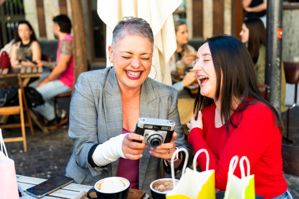 两个快乐的朋友在西班牙穆尔西亚大笑并展示照片图片下载