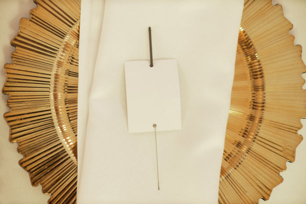 婚礼当天新娘桌上的金色盘子和装饰性空白纸张的照片。图片下载