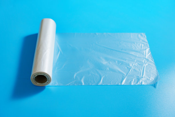 蓝色背景上的透明包装袋卷。图片下载