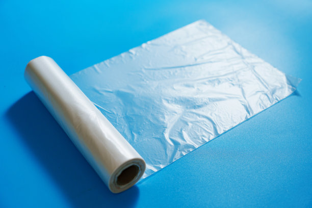 蓝色背景上的透明包装袋卷。图片下载