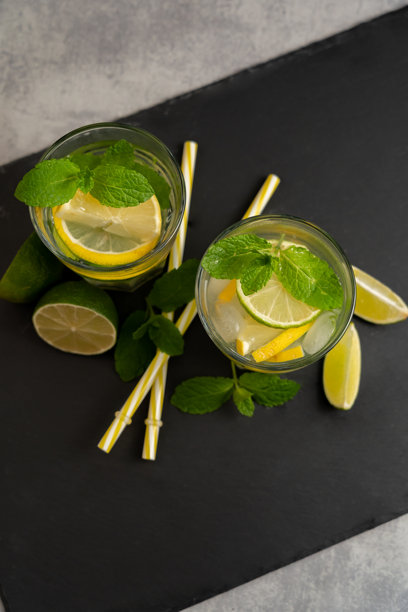 两杯柠檬薄荷饮料，上面放有香茅，拍摄于黑色表面，俯视角度。食品照片用于目录、出版物和杂志。图片下载
