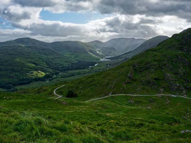 在这张照片中，发现爱尔兰自然美景的魅力。柔和的山坡和蜿蜒的小路勾勒出如画的风景。图片下载