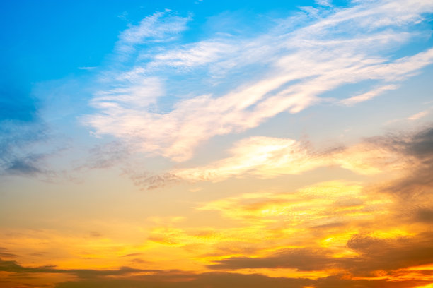 美丽奢华的柔和渐变橙金色云彩和阳光映衬在蓝天上，完美适合作为背景，拍摄于黄昏时分，清晨，超大尺寸，高分辨率的风景照片图片下载