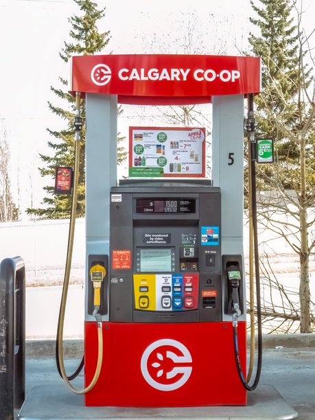 卡尔加里合作社的加油泵在冬日的一个加油站准备就绪，显示着燃油价格和品牌标识。图片下载