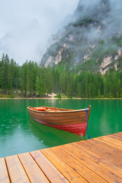 意大利多洛米蒂的布拉耶斯湖上的小船。湖面和水面的倒影。夏季的山地风景。适合登山、旅行和度假的地方。壁纸、明信片、照片。图片下载