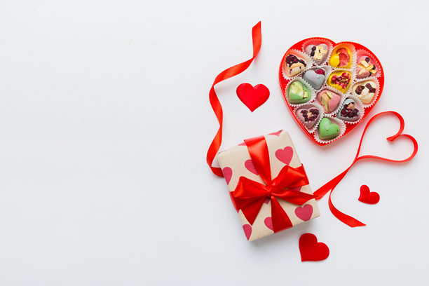 情人节构图：甜美的糖果，带有蝴蝶结的礼品盒和红色毛毡心，照片模板，背景。俯视图，留白空间。图片下载