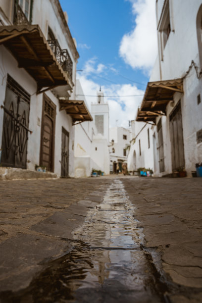 摩洛哥特图安的老城区，非洲。街头摄影。特图安街道和拱门。阿拉伯和穆斯林国家及生活方式。水面倒影。图片背景中的清真寺。图片下载