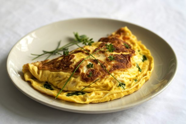 一张完美煎制的煎蛋卷放在白色陶瓷盘上的照片图片下载